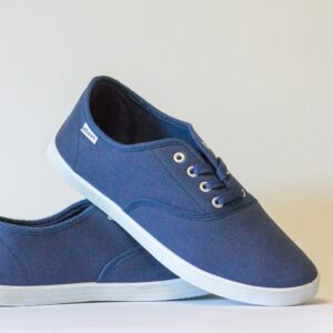 Pair of stylish blue canvas shoes with white soles displayed against a neutral background.